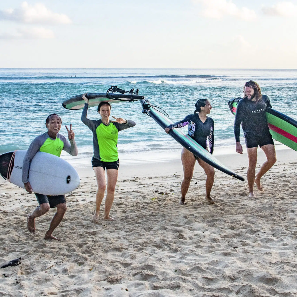 Group coming in from a surf laughing together.